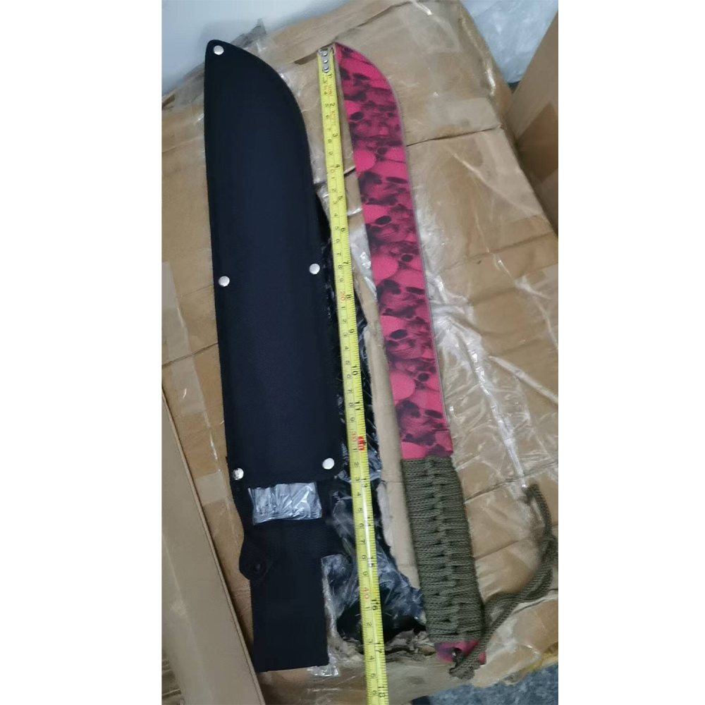 Distinctive machete with skull-patterned curved blade and green cord-wrapped handle shown with black riveted sheath and measuring tape