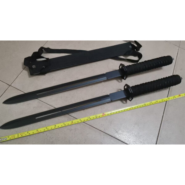 Two black swords with textured grips and hole-pierced blade alongside sheath on light-tile floor - Yellow tape shows length